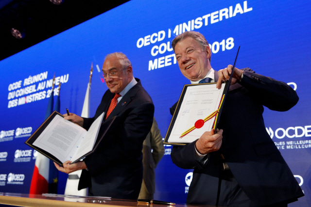 후안 마누엘 산토스(오른쪽) 콜롬비아 대통령과 앙헬 구리아 경제협력개발기구(OECD) 사무총장이 30일(현지시간) 프랑스 파리에서 콜롬비아의 OECD 가입합의문에 서명한 후 활짝 웃고 있다.     /파리=AFP연합뉴스