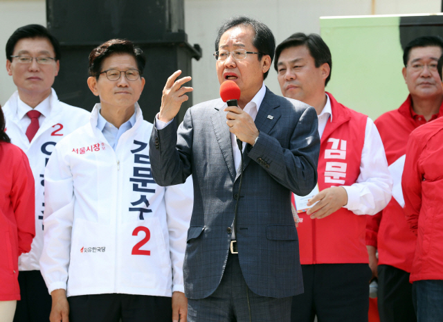 자유한국당의 홍준표(가운데) 대표가 31일 오전 서울역에서 열린 김문수(왼쪽) 서울시장 후보 출정식에서 시민들에게 지지를 호소하고 있다. /연합뉴스