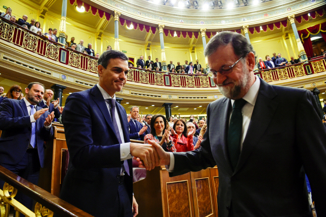 스페인 의회의 1일(현지시간) 불신임안 통과로 실각하게 된 마리아노 라호이(오른쪽) 총리와 새 총리가 된 페드로 산체스 사회당 대표가 마드리드의 의사당에서 악수하고 있다.   /마드리드=로이터연합뉴스