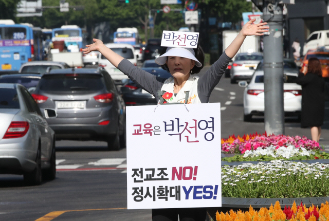 31일 오전 서울 광화문광장에서 박선영 서울시교육감 후보가 “전교조 NO, 정시확대 YES”라고 쓴 피켓을 목에 걸고서 출근길에 오른 시민들을 향해 지지를 호소하고 있다./출처=연합뉴스