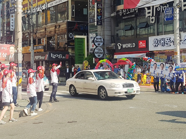 4일 경남 창원시 성산구 상남시장 앞 사거리에서 더불어민주당과 자유한국당 선거운동원들이 길 하나를 사이에 두고 치열한 홍보전을 벌이고 있다. /창원=류호기자