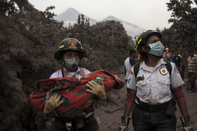 4일(현지시간) 과테말라 푸에고 화산 폭발로 숨진 어린이를 한 소방대원이 안아 옮기고 있다. 화산이 이틀 연속 분화하면서 사망자는 62명을 넘어섰다, /과테말라=AP연합뉴스