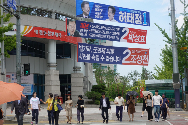 5일 대전광역시 서구 둔산로 거리에서 대전시장 후보들의 현수막 아래로 시민들이 길을 건너고 있다.  　 /대전=양지윤기자