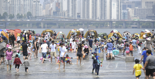 서울 기온이 30도 내외로 여름 날씨를 보인 6일 오후 현충일 휴일을 맞은 시민들이 여의도 한강 시민공원 물빛 광장에서 물놀이를 하며 더위를 식히고 있다./송은석기자