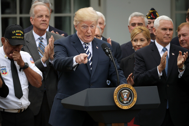 도널드 트럼프 미국 대통령이 6일(현지시간) 워싱턴 백악관 로즈가든에서 열린 퇴역군인 지원법안 서명행사에서 발언하고 있고 마이크 펜스(앞줄 오른쪽) 부통령이 박수를 치고 있다. /AFP연합뉴스