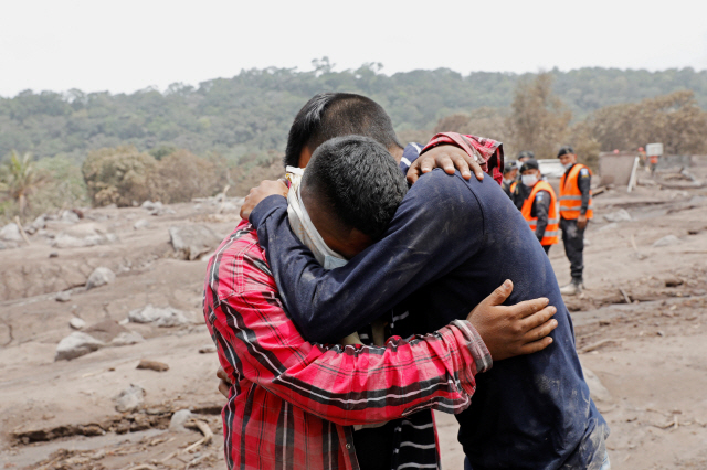 7일(현지시간) 과테말라 에스쿠인틀라에서 화산폭발로 13명의 가족을 잃은 한 청년이 위로를 받고 있다. /에스쿠인틀라=로이터연합뉴스