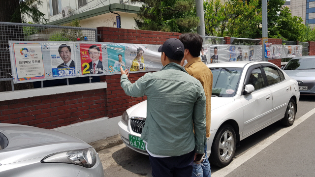 사전투표가 시작된 8일 경북 포항의 죽도동 주민센터 인근에서 시민들이 경북지사 후보자들의 선거 벽보를 보고 있다./포항=박우인 기자