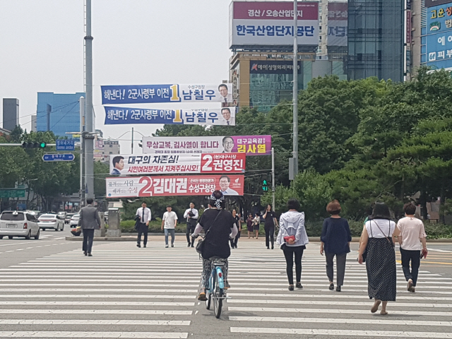 8일 대구시 수성구 범어동 사거리 횡단보도에서 대구시민들이 6·13지방선거에 출마한 후보들의 플래카드를 보며 길을 건너고 있다./대구=류호기자