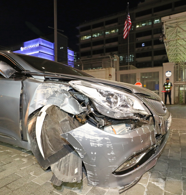 지난 7일 서울 광화문 주한미국대사관 출입문으로 돌진한 차량이 심하게 부서진 채로 옆 도로로 견인되어 있다. /연합뉴스