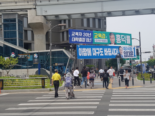 8일 대구시 수성구 황금동 황금네거리 횡단보도에서 시민들이 6·13지방선거 후보들의 플래카드를 보며 걸어가고 있다./대구=류호 기자