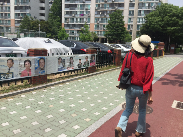 7일 오전 서울특별시 노원구 수락산역 인근 아파트단지에서 한 시민이 선거 포스터를 유심히 살펴보고 있다./하정연 기자