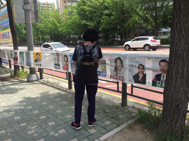 7일 서울특별시 노원구 마들역 사거리에서 한 시민이 발걸음을 멈추고 노원병 지역 선거 포스터를 유심히 살펴보고 있다./하정연 기자