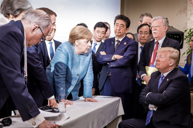 주요7개국(G7) 정상회의 이틀째인 9일(현지시간) 캐나다 퀘벡주 라말베의 회의장에서 도널드 트럼프(오른쪽) 미국 대통령이 앙겔라 메르켈(가운데) 독일 총리의 주장을 팔짱을 낀 채 심드렁한 표정으로 듣고 있다. /라말베=UPI연합뉴스
