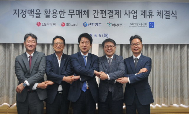 지난 5일 서울 마포구 LG히다찌 본사에서 박정우(왼쪽부터) 나이스정보통신 법인사업본부장, 김정수 신한카드 디지털사업본부장, 이석희 LG히다찌 솔루션&서비스사업본부장, 최정윤 비씨카드 디지털혁신본부장, 정성민 하나카드 미래사업본부장이 생체 인증 기술인 지정맥을 활용한 ‘무매체 간편 결제 사업’ 추진을 위한 제휴조인식을 갖고 악수하고 있다. /사진제공=신한카드