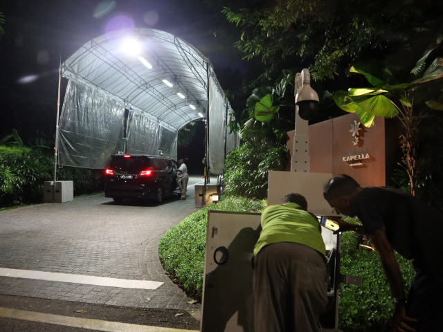 북미 정상회담 개최지인 싱가포르 카펠라호텔의 보안 인력들이 지난 9일 밤 진입로 앞에 설치된 보안 카메라를 점검하고 있다. 뒤편에는 또다른 보안 인력이 진입 차량에 정차를 요구한 후 탑승자를 확인하고 있다. /싱가포르=정영현기자