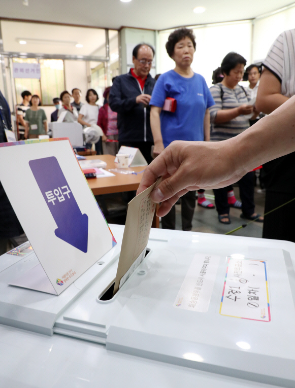 8일 오전 부산 동구 수정1동 주민센터에 마련된 사전투표소에서 한 유권자가 투표하고 있는 모습./연합뉴스