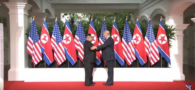 도널드 트럼프(오른쪽) 미국 대통령과 김정은 북한 국무위원장이 12일 오전 9시 싱가포르 센토사 섬 카펠라 호텔에서 만나 악수를 하고 있다. /스트레이츠타임스 캡쳐