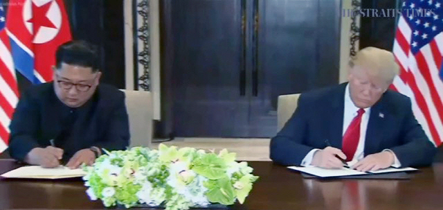 역사적 첫 북미정상회담이 열린 12일 오후 싱가포르 센토사 섬 카펠라호텔에서 미국 도널드 트럼프 대통령과 북한 김정은 국무위원장이 합의문에 서명하고 있다./출처=연합뉴스