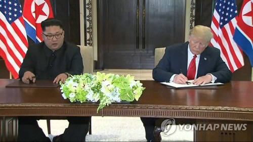 북한 김정은 국무위원장과 미국 도널드 트럼프 대통령이 합의문에 서명을 하고 있다./출처=연합뉴스