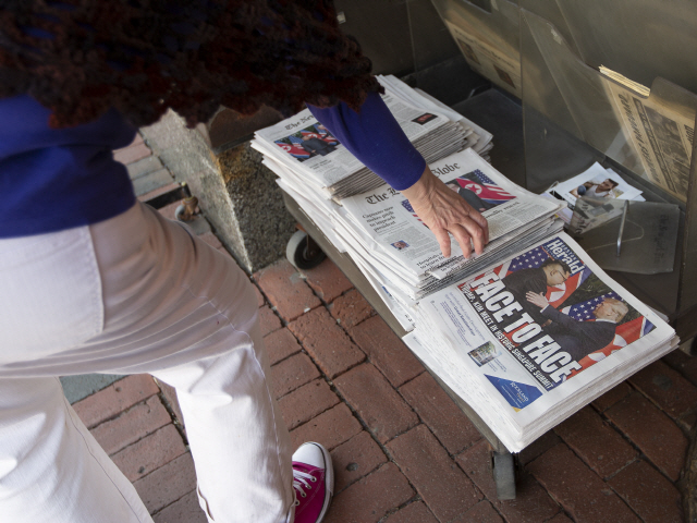 한 미국 시민이 12일(현지시간) 매사추세츠 캠브리지 가판대에서 신문을 집어들고 있다. /캠브리지=EPA연합뉴스