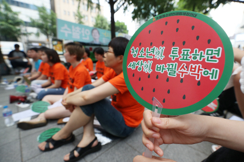 전국동시지방선거일인 13일 오후 서울 종로구 광화문에서 열린  선거연령 하향과 청소년 참정권 보장을 촉구하는 집회에서 한 참석자가 주최 측이 배포한 부채를 들고 있다. /연합뉴스