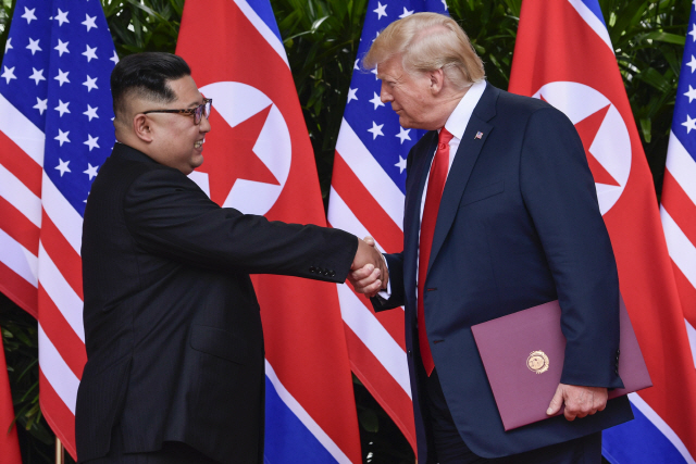 도널드 트럼프(오른쪽) 미국 대통령이 지난 12일(현지시간) 싱가포르에서 김정은 북한 국무위원장과 악수하고 있다. /싱가포르=AP연합뉴스
