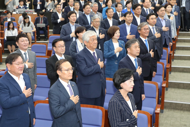 더불어민주당 추미애 대표와 홍영표 원내대표 등 의원들이 지난 14일 국회에서 열린 의원총회에서 국기에 경례하고 있다./출처=연합뉴스