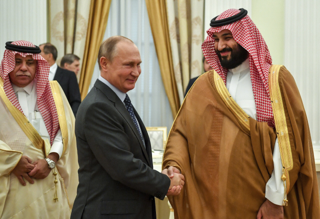 Russian President Vladimir Putin, center, shakes hands with Saudi Arabia Crown Prince Mohammed bin Salman, right, during their meeting in Moscow, Russia, Thursday, June 14, 2018. (Yuri Kadobnov, Pool Photo via AP)      <저작권자(c) 연합뉴스, 무단 전재-재배포 금지>