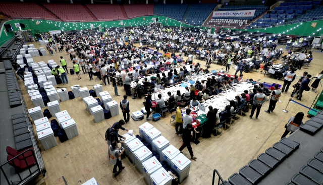 제7회 전국동시지방선거 및 국회의원 재ㆍ보궐선거 사전투표가 끝난 13일 오후 서울 송파구 잠실실내체육관에 마련된 광진구개표소에서 개표사무원들이 투표용지를 개표하고 있다./연합뉴스