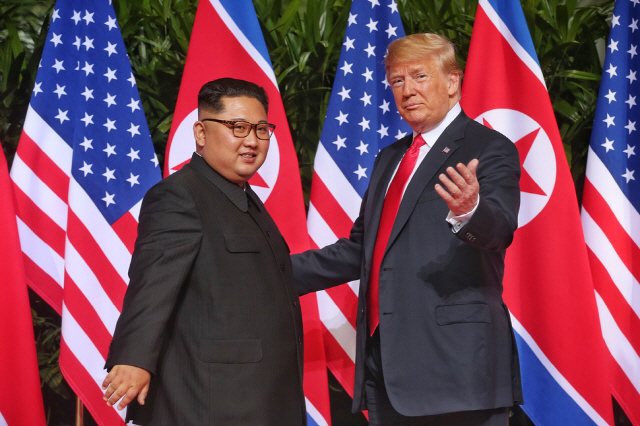김정은 북한 국무위원장과 도널드 트럼프 미국 대통령이 12일(현지시각) 싱가포르 카펠라 호텔에서 만나 악수한 뒤 사진 촬영을 위해 취재진을 잠시 바로보고 있다. 사진=스트레이츠 타임스 제공