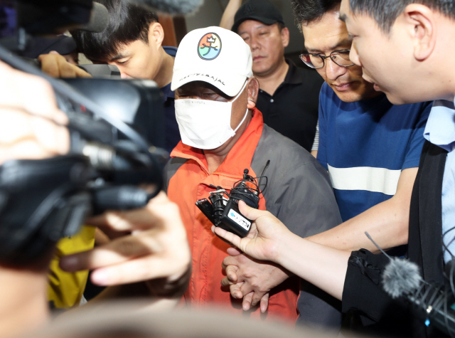 전북 군산시 장미동 한 주점에 불을 지른 혐의로 긴급체포된 이모(55)씨가 18일 새벽 병원 치료를 받기 위해 군산경찰서를 나가고 있다./연합뉴스