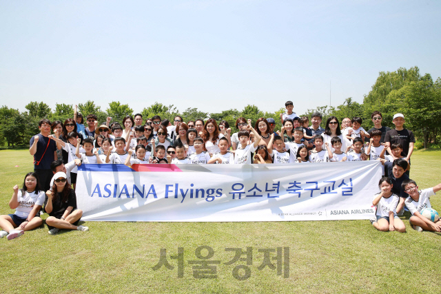 아시아나항공 임직원과 자녀 등 60여명이 서울 강서구 아시아나타운 내 잔디광장 ‘벨루스 가든’에서 ‘아시아나 유소년 축구교실을 마친 후 화이팅을 외치고 있다. 아시아나항공은 임직원 자녀들의 신체와 정서발달을 돕기 위해 지난 16일과 17일 외부전문강사를 초빙해  축구교실을 열었다./사진제공=아시아나항공