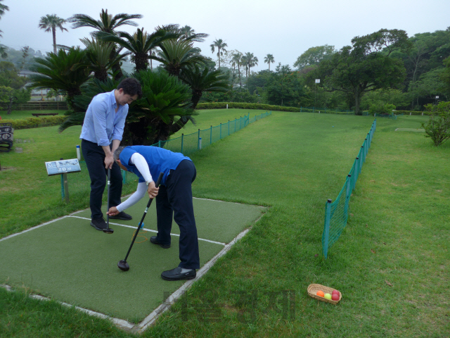 ‘아오시마 파크 골프장’을 찾은 여행객이 강사로부터 골프 강습을 받고 있다.