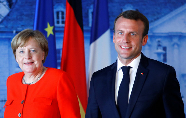 앙겔라 메르켈(왼쪽) 독일 총리와 에마뉘엘 마크롱 프랑스 대통령이 19일(현지시간) 독일 메세베르크에서 정상회담을 연 뒤 기자회견에 참석해 밝게 웃고 있다.           /메세베르크=로이터연합뉴스