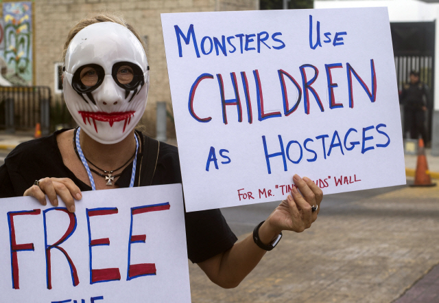 21일(현지시간) 멕시코 유카탄주의 주도 메리다에서 한 활동가가 ‘괴물이 아이들을 인질로 사용하고 있다’는 펫말을 들고 시위를 하고 있다. /메리다=EPA연합뉴스