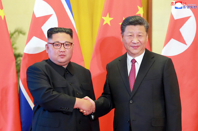 김정은 북한 국무위원장이 지난 20일(현지시간) 중국을 방문해 시진핑 국가 주석과 악수를 나누고 있다. /베이징=UPI연합뉴스