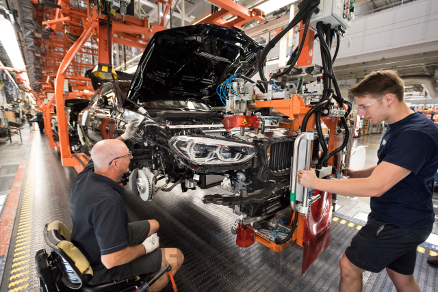 미국 스파르탄버그 BMW 공장 조립라인에서 작업자들이 차체에 엔진을 조립하고 있는 모습. /사진제공=BMW그룹코리아