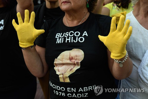 스페인 마드리드 법원 앞에서 한 시위 참가자가 ‘1976년 카디즈에서 태어난 나의 아이를 찾고 있습니다’라고 적힌 티셔츠를 입고 서 있다./출처=연합뉴스