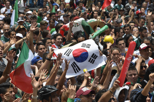 멕시코 축구 팬들이 28일 멕시코시티 광장에서 멕시코 대표팀의 러시아월드컵 16강 확정에 태극기를 펼쳐 들고 기뻐하고 있다.  /멕시코시티=AFP연합뉴스