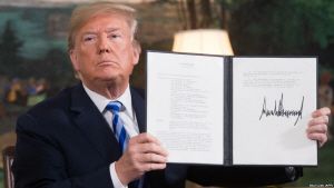 도널드 트럼프 미국 대통령이 이란 핵 합의를 파기하고 제재를 복원하는 행정문서에 서명한 것을 보여주고 있다.