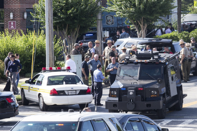 28일(현지시간) 미국 메릴랜드의 주도 아나폴리스에 있는 한 지역 신문사 편집국에서 벌어진 총격 사건을 수사하기 위해 경찰들이 모여있다. /아나폴리스=AFP연합뉴스