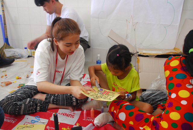 지난달 29일 베트남 푸옌 지역의 푸옌병원에서 SK자원봉사단 SK써니 단원들이 다지증 수술을 받은 어린이와 놀이수업을 하고 있다. /사진제공=SK그룹