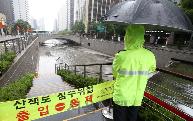 장마전선의 영향으로 전국에 폭우가 쏟아지고 있는 1일 경찰이 침수 위험에 놓인 서울 청계천의 산책로 출입을 통제하고 있다./송은석기자