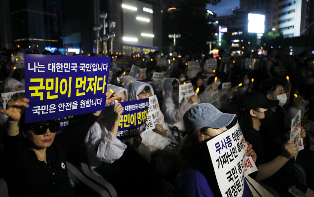 지난달 30일 오후 서울 종로구 동화면세점 앞에서 열린 난민법과 무사증(무비자) 제도 폐지 집회에서 참가자들이 손팻말을 들고 있다. / 연합뉴스