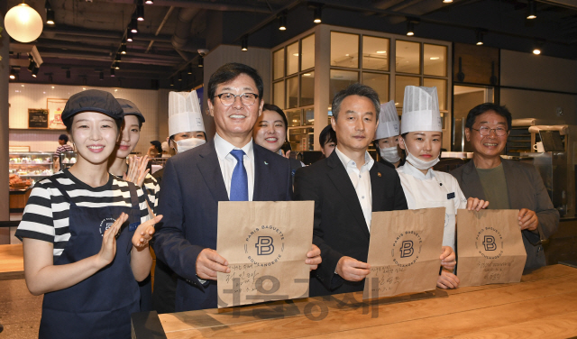 2일 오전 서울 파리바게트 명동점에서 열린 '1회용품 줄이기 및 재활용 촉진을 위한 자발적 협약'에 참석한 권인태(앞줄 왼쪽 두번째부터) 파리크라상 대표, 안병옥 환경부 차관, 이철수(오른쪽) 환경연합 대표가 비닐 대신 종이봉투를 들고 1회용품 사용 자제를 독려하는 기념 촬영을 갖고 있다./송은석기자