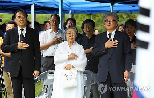 2013년 8월 17일 오전 경기도 파주시 탄현면 성동리에서 열린 ‘故 장준하선생님 38주기 추모식’에서 참석자들이 국민의례를 하고 있다. 사진 왼쪽부터 故 장준하 선생의 장남 장호권, 미망인 김희숙 여사, 유광언 장준하선생기념사업회 운영위원장. (사진=연합뉴스)