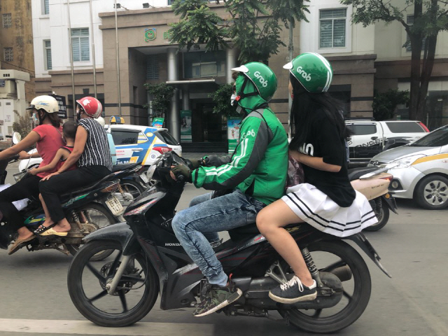 지난달 28일 베트남 하노이 시내에서 한 여성이 그랩 바이크를 이용해 이동하고 있다. 하노이 시내 곳곳에서는 초록색 그랩 티셔츠를 입은 기사들을 어렵지 않게 볼 수 있다. /하노이=한재영 기자
