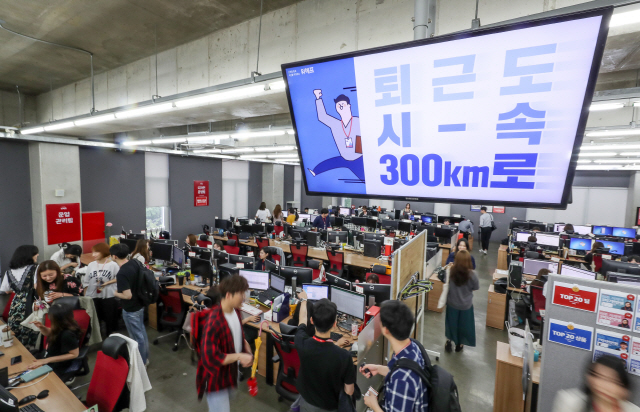 주52시간 근무제 시행 첫 날인 2일 오후 서울 강남구에 위치한 전자상거래 기업 위메프 본사에서 직원들이 정시 퇴근을 하고 있다. 사무실 천정에 걸린 ‘퇴근도 시속 300㎞’라고 쓰인 캠페인 문구가 눈길을 끈다./연합뉴스