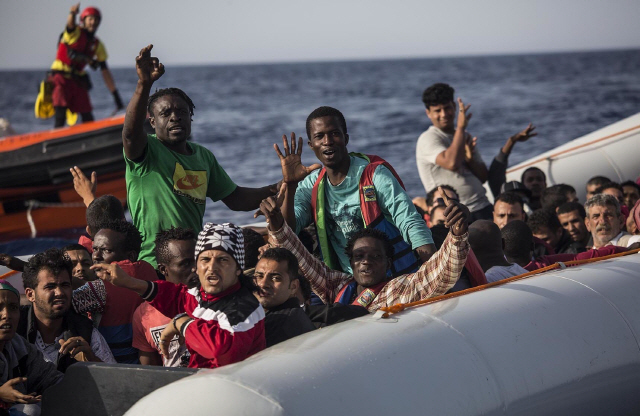 지난달 30일(현지시간) 리비아 인근 지중해에서 고무보트를 타고 표류하던 난민들이 스페인 구호단체 프로악티바 오픈 암스 대원들에게 도와달라며 흔들고 있다./출처=연합뉴스