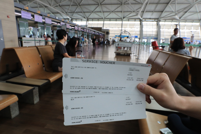 아시아나항공 기내식 대란이 3일 사흘째 계속되고 있는 가운데 한 승객이 인천공항에서 아시아나항공으로부터 받은 1만원권 서비스 쿠폰을 보여주고 있다. /연합뉴스